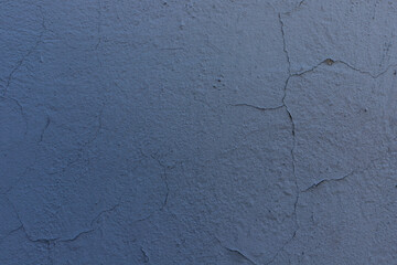 Cracked blue paint on the wall. Old peeling painted textured background