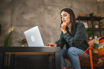 Adult upset woman sit and use laptop at home stress,problem, negative