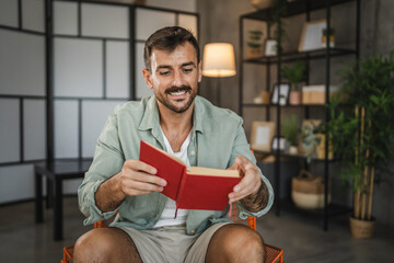 Adult relax man smile and sit on a chair and read a book