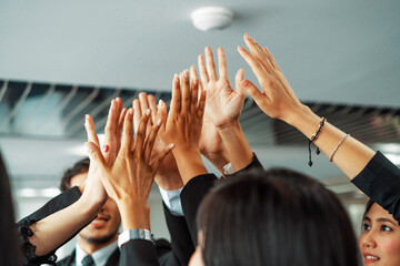 Many happy business people raise hands together with joy and success. Company employee celebrate...