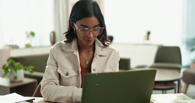 Laptop, Indian woman and home for online, typing or remote work from living room with computer. Lounge, glasses or internet for language transcriber, technology or website for freelance female person