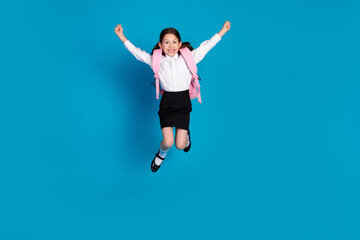 Fototapeta premium Full length portrait of little schoolkid jump raise fists wear uniform isolated on blue color background