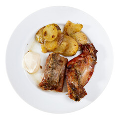 Lunch is served on plate - pieces of young rabbit baked with slice of potato. Close-up, top view. Isolated over white background © JackF