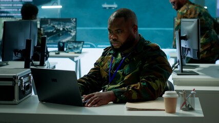 Intelligence agents in modern operations center managing surveillance activity and synchronizing...