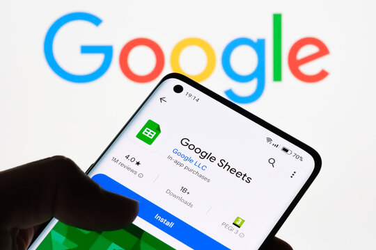 Cellphone screen displaying Google Sheets app with Google logo in the background, illustrating the connection between Google Sheets and Google, Stafford, United Kingdom, August 8, 2024..