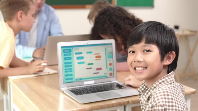 Energetic asian boy coding program and looking at camera in STEM class while caucasian teacher and diverse friend drawing mind map together. Student learning generated AI and writing code. Pedagogy.