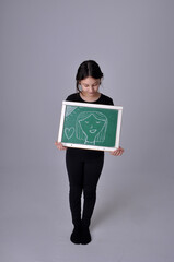 garota estudante faz desenho com giz no quadro 