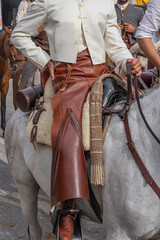 A horse rider in leather chaps at a Spanish festival.