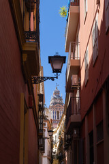 A church tower from a narrow Spanish alley.