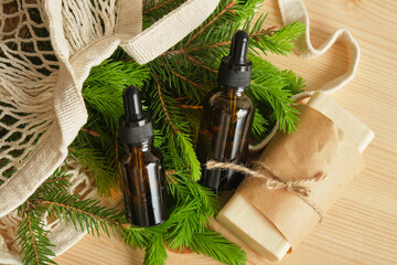 glass amber bottles with pipettes and spruce branches with young needles