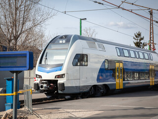 Obraz premium A modern double-decker electric multiple unit (EMU) train designed for regional and suburban traffic, captured at a train station. The train features advanced technology for efficient passenger transp