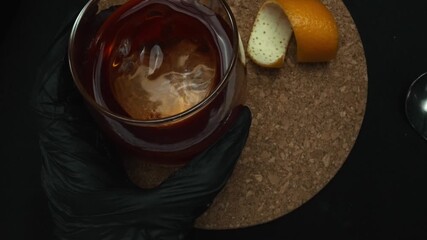 Top view of a Negroni cocktail takes center stage, adorned with a vibrant orange slice against a sleek black background. Each meticulous close-up shot captures of cocktail. Macrography. Comestible.