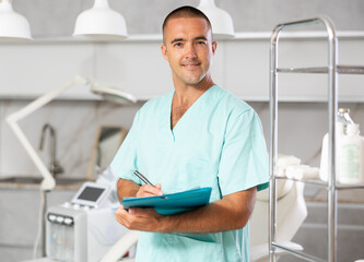 Doctor meticulously documents and giving advices procedures beside cosmetic chair.