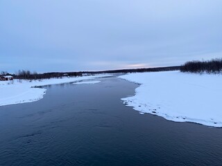 Beautiful cold winter day, river surrounded by snow