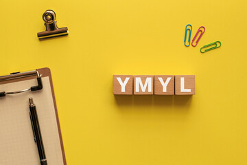 There is notebook with the word YMYL. It is an abbreviation for Your Money or Your Life as...