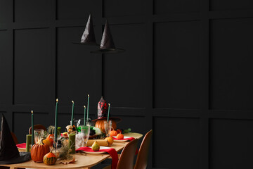 Festive table with pumpkins and burning candles served for Halloween party at home
