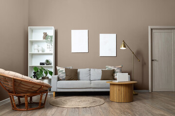 Interior of stylish living room with grey sofa, armchair and laptop on coffee table