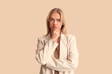 Young thoughtful businesswoman on beige background. Business idea concept