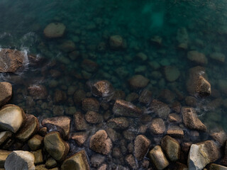 Long exposure image of Dramatic sky seascape with rocks and waves crashing on seashore
