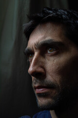 rostro pensativo, poco iluminado en fondo oscuro 