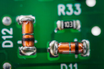 Small glass diodes on a printed circuit board.
