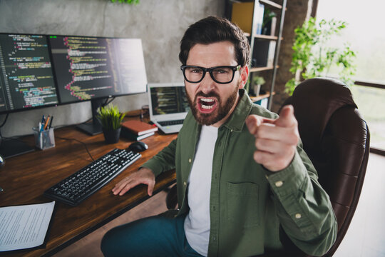 Photo of professional it specialist young man shout point finger you computer desktop loft interior office indoors