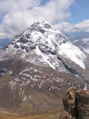 The pointed glacial and snowy peak of the Illinizas Sur volcano view from the slopes of the Illinizas Norte