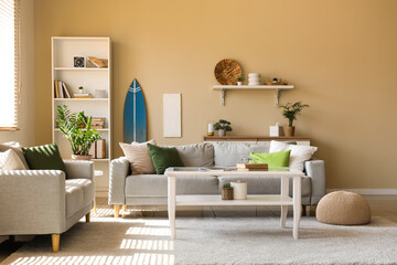Interior of living room with cozy sofa, table and surfboard