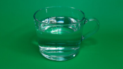 glass of water on green background