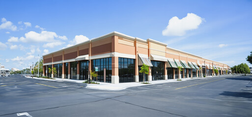 Obraz premium Spacious Retail Storefront With Clear Blue Sky and Unoccupied Parking Area During Daylight Hours