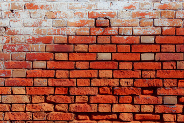 Old grungy red brick wall. Free space for an inscription. Fragment of a wall with bumps and peeling paint.