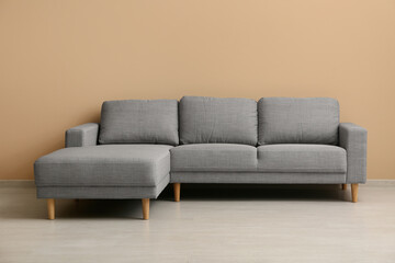 Cozy sofa near beige wall in living room