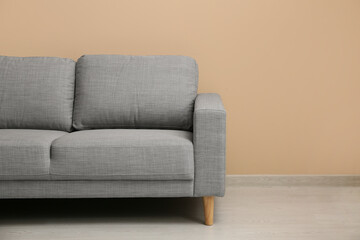Cozy sofa near beige wall in living room