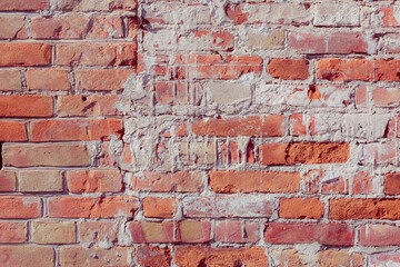 Old grungy red brick wall. Free space for an inscription. Fragment of a wall with bumps and peeling paint.