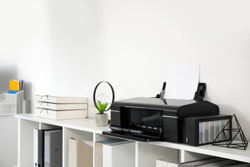 Modern printer on shelving unit in stylish office