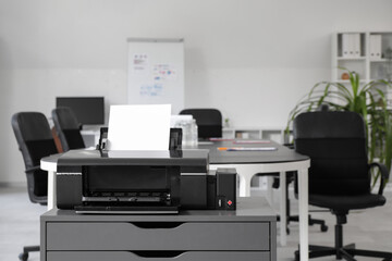 Modern printer on chest of drawers in stylish office
