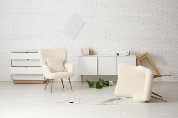 Interior of damaged living room with armchairs after earthquake