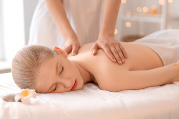 Young woman having spine massage in spa salon