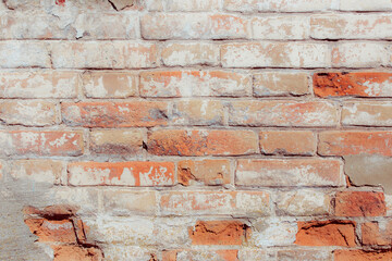 White old grungy brick wall. Fragment of a wall with bumps and peeling paint. Restoration of semi-antique brick walls. A basic neutral background for a design project.