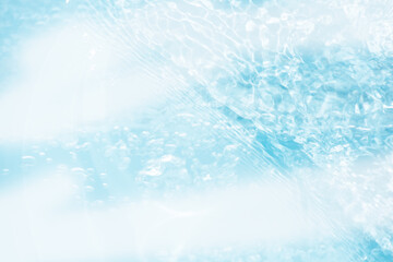 Blue water with ripples on the surface. Defocus blurred transparent blue colored clear calm water surface texture with splashes and bubbles. Water waves with shining pattern texture background.