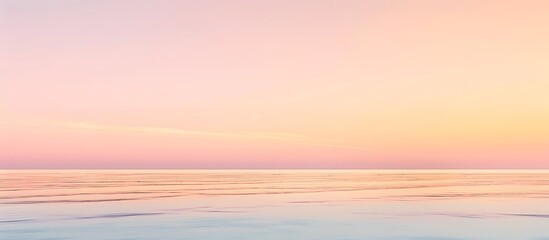 Fototapeta premium Soft gradients of pastel pinks and oranges create a serene sunrise horizon.