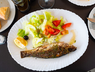 Delicious grilled seabass seasoned with olive oil, herbs, and garlic, paired with crispy colorful...