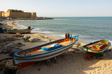 Traditional fishing boats resting on sandy shore Mediterranean Sea in Tunisian town of of Hammamet...