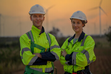 Team Engineers men and woman checking and inspecting on construction with sunset sky. people operation. Wind turbine for electrical of clean energy and environment. Industrial of sustainable.