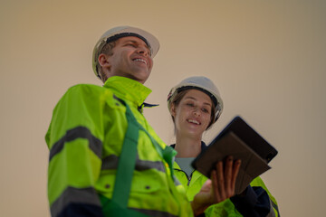 Team Engineers men and woman checking and inspecting on construction with sunset sky. people operation. Wind turbine for electrical of clean energy and environment. Industrial of sustainable.