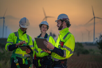 Fototapeta premium Team Engineers men and woman checking and inspecting on construction with sunset sky. people operation. Wind turbine for electrical of clean energy and environment. Industrial of sustainable.