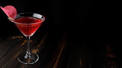 Red cocktail with rose decoration in a martini glass