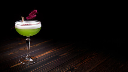 Green cocktail in a cocktail glass with decorations