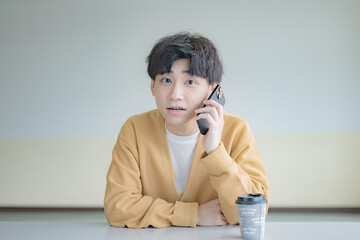 驚き顔の通話する私服男性