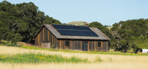 Obraz premium Solar-Powered Barn Surrounded by Lush Green Fields in Rural Landscape During Bright Daylight
